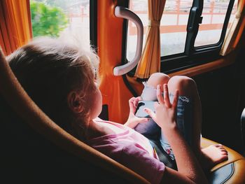 Girl using smart phone while sitting in bus