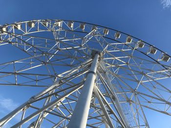 Low angle view of ferris wheel against blue sky