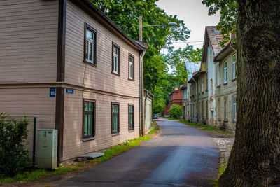 Empty road amidst buildings in city