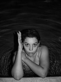 Portrait of young woman sitting in swimming pool