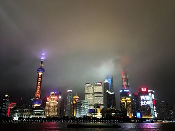 Low angle view of illuminated cityscape against sky at night