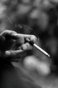 Close-up of hand holding cigarette