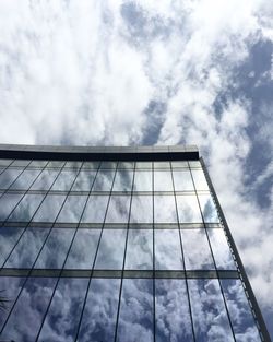 Low angle view of modern building against cloudy sky