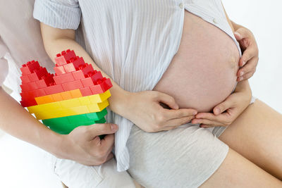 Midsection of woman holding multi colored umbrella