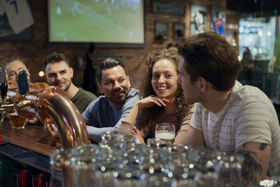 Smiling friends sitting at bar