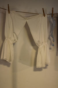 Clothes drying on clothesline against white wall