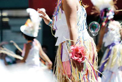 Side view mid section of kids doing traditional dance on road