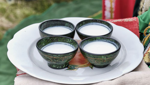 Four bowls with traditional bashkir pattern, filled with mare's milk or koumiss, national drink