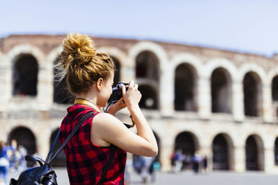 Italy, verona, woman taking picture of verona arena