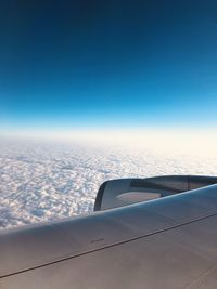 Airplane flying over clouds against blue sky
