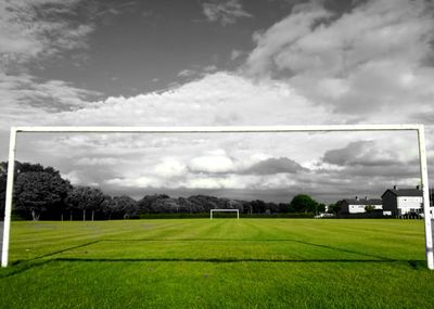 Scenic view of grassy field against cloudy sky