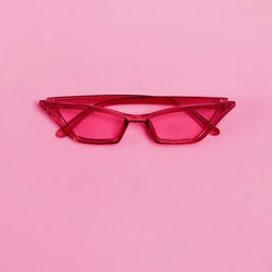 Close-up of sunglasses against pink background