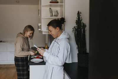 Smiling female couple standing in kitchen