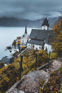 View from uphill of christuskirche church bell tower with stairs trail in foreground in hallstatt