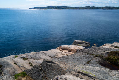 High angle view of rocks by sea against sky