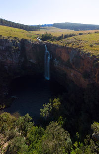 Scenic view of waterfall against sky