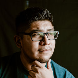 Portrait of young man against black background