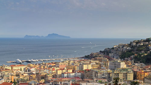 High angle view of cityscape by sea against sky