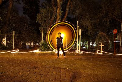 Full length of man standing on footpath at night