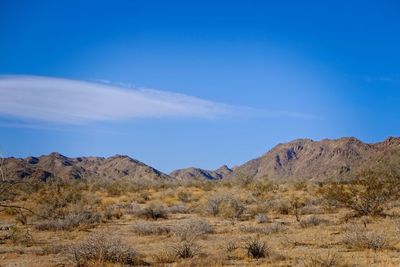 Scenic view of mountains against blue sky