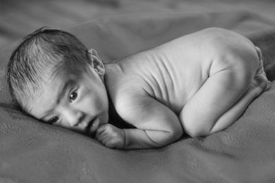 Portrait of cute baby lying on bed