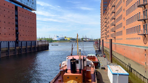 Boats in canal amidst buildings in city