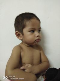 Portrait of cute baby girl against wall