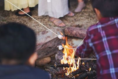 People holding marshmallows over fire