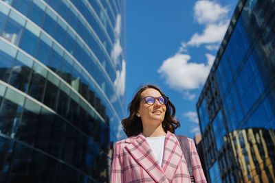 Low angle view of woman standing against sky