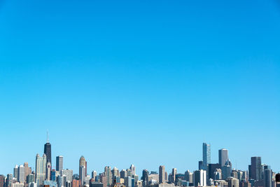 Low angle view of skyscrapers against blue sky