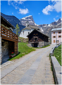 Footpath amidst buildings against sky
