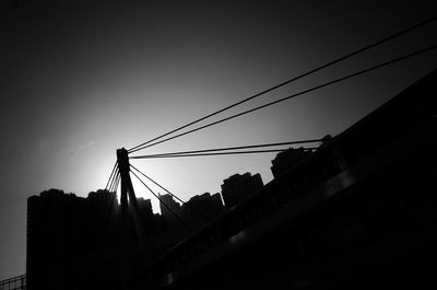 Low angle view of silhouette cables against sky