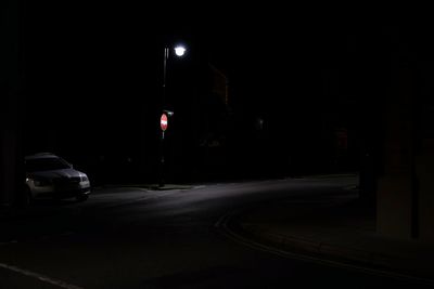 Road passing through illuminated city at night