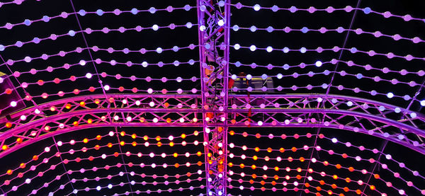 Low angle view of illuminated ferris wheel at night