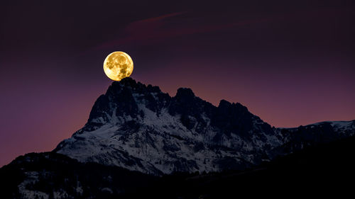 Scenic view of snowcapped mountains against sky at night