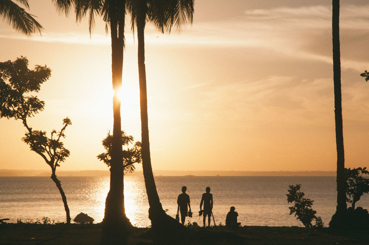 SILHOUETTE PEOPLE ON BEACH AT SUNSET