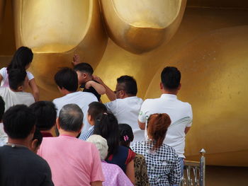 Rear view of people sitting in corridor