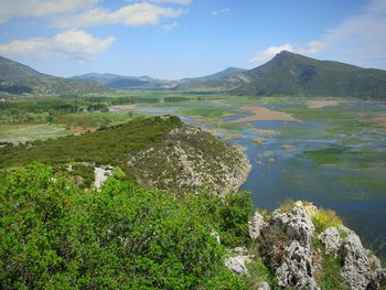 Scenic view of lake by mountains against sky