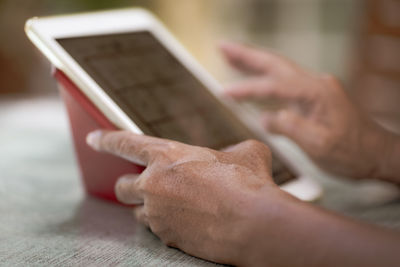 Senior asian man using tablet to play social media at home during free time