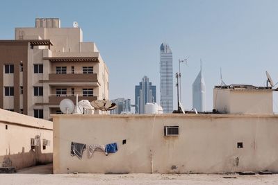 Buildings in city against clear sky