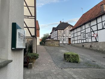 Street amidst houses and buildings against sky