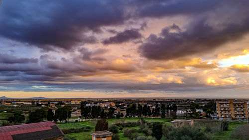 Aerial view of buildings against sky during sunset