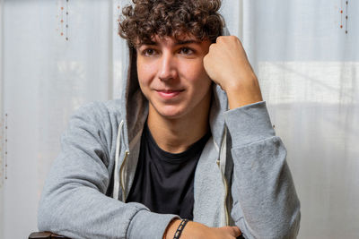 Close-up of young man looking away sitting at home