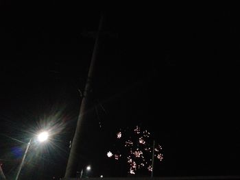 Low angle view of illuminated lights against sky at night