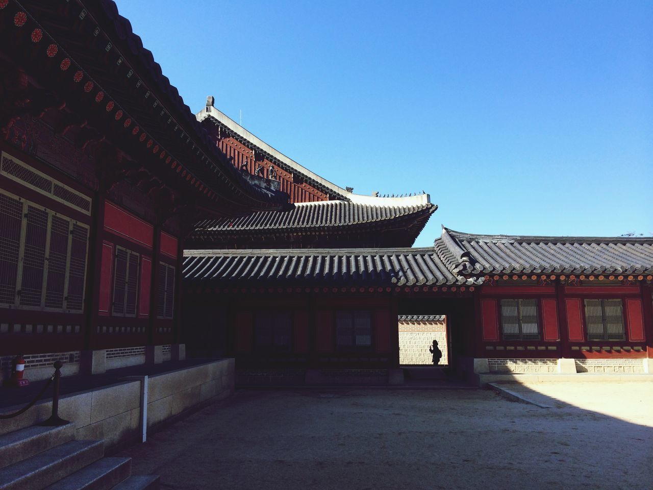 architecture, built structure, building exterior, clear sky, roof, house, blue, copy space, residential structure, exterior, sunlight, facade, residential building, outdoors, day, low angle view, no people, shadow, history, steps