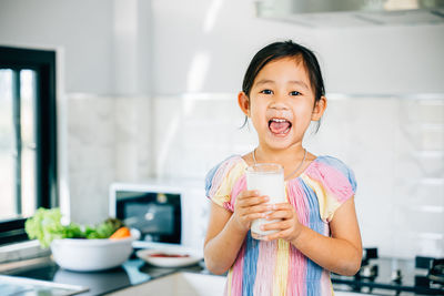 Portrait of young woman drinking coffee at home