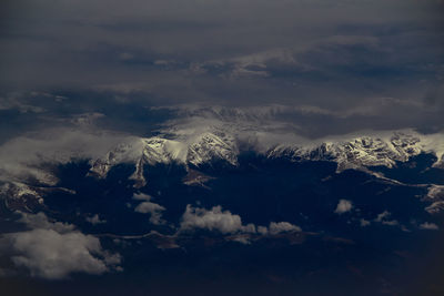 Scenic view of silhouette mountains against sky during winter