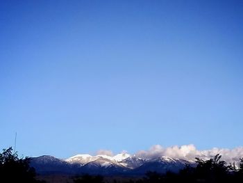 Scenic view of snowcapped mountains against clear blue sky