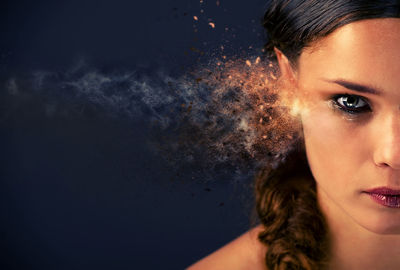 Cropped portrait of young woman over blue background 