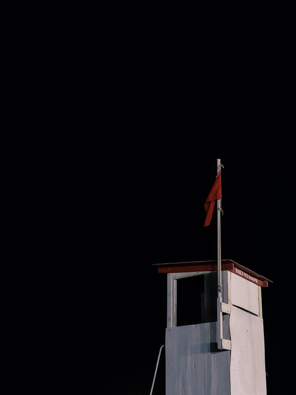 LOW ANGLE VIEW OF FLAG AGAINST BUILDING AT NIGHT